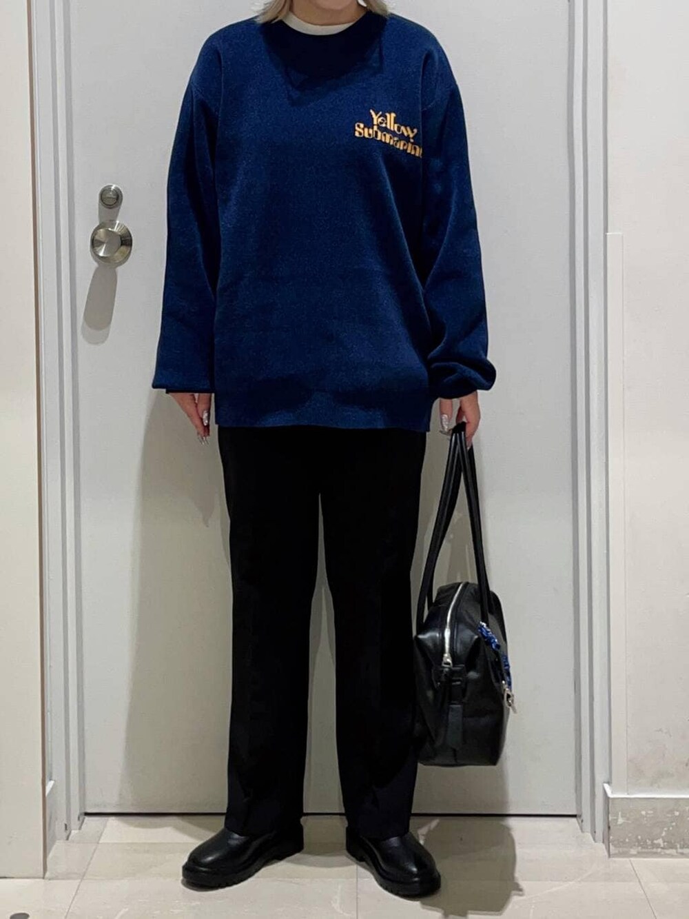 ブラック系のボストンバッグ、ブラック系のその他パンツ、ホワイト系のTシャツ/カットソーを着用したレディースの冬コーディネートの2枚目の写真