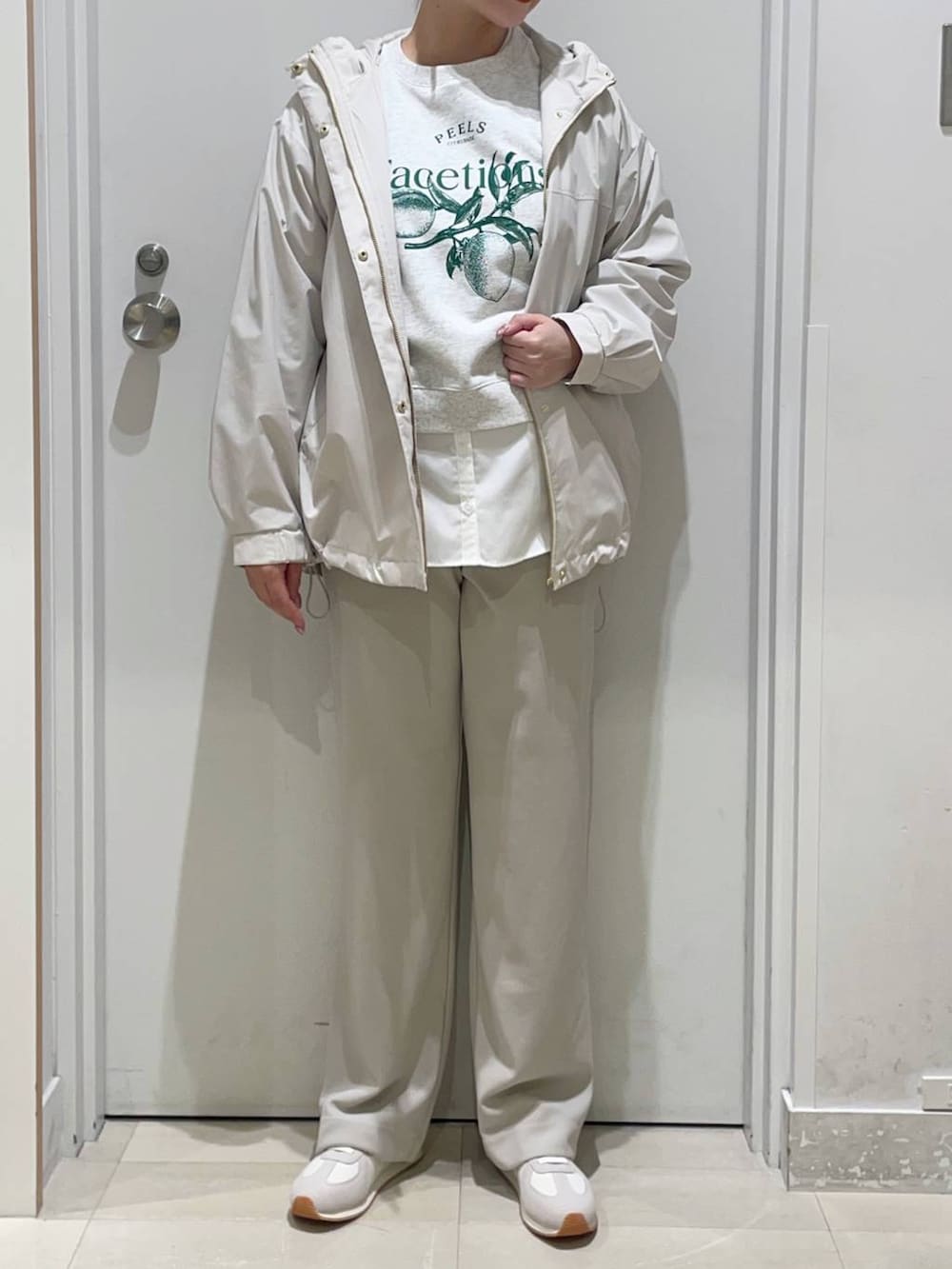 ベージュ系のスニーカー、ホワイト系のTシャツ/カットソー、ベージュ系のマウンテンパーカーを着用したレディースの春コーディネートの2枚目の写真