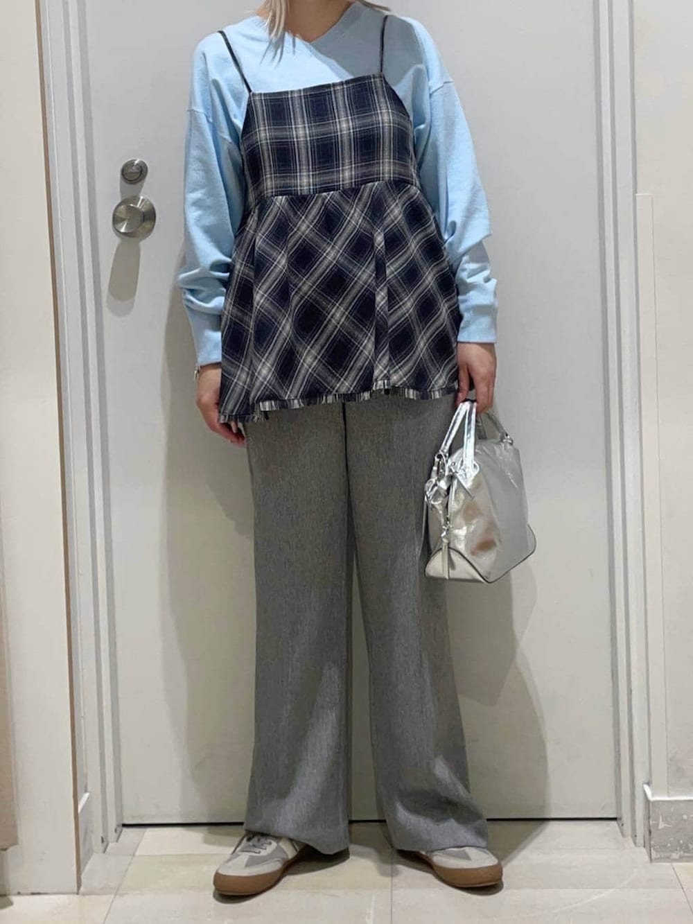 シルバー系のショルダーバッグ、グレー系のスニーカー、ブルー系のニット/セーターを着用したレディースの冬コーディネートの2枚目の写真