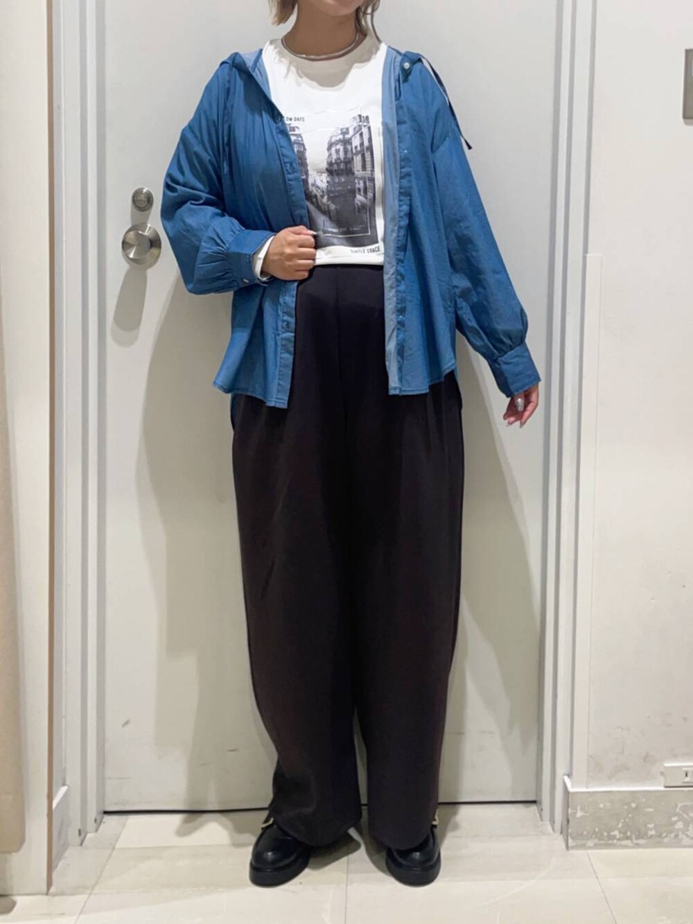 ブルー系のシャツ/ブラウス、ブラック系のローファー、ホワイト系のTシャツ/カットソーを着用したレディースの秋コーディネートの2枚目の写真