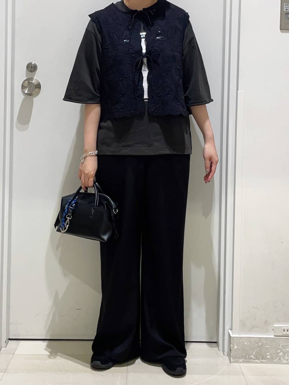 ブラック系のベスト、ブラック系のその他パンツ、グレー系のスウェットを着用したレディースの春コーディネートの2枚目の写真