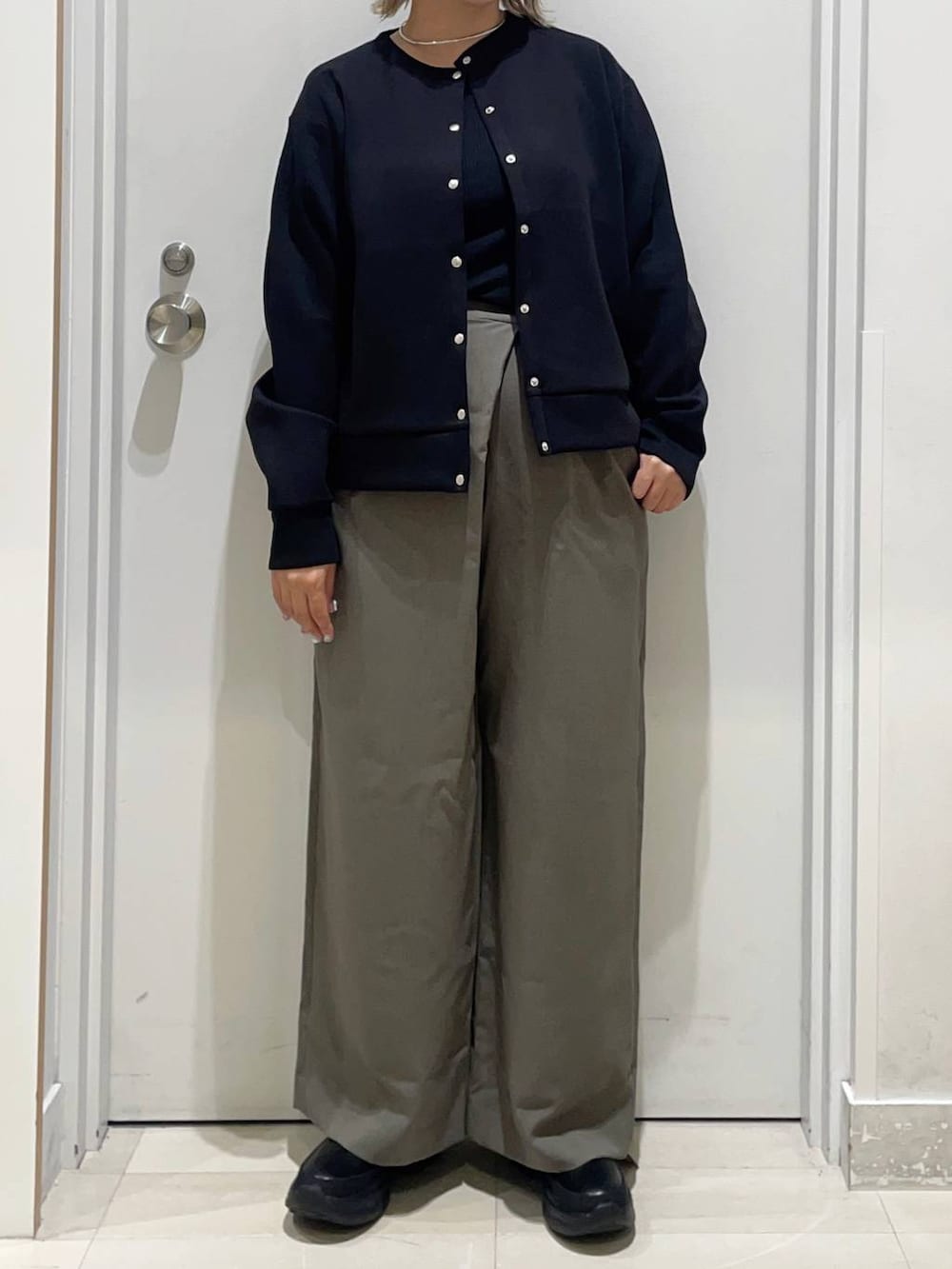 ブラック系のTシャツ/カットソー、ブラック系のカーディガン/ボレロ、ブラック系のブーツを着用したレディースの秋コーディネートの2枚目の写真