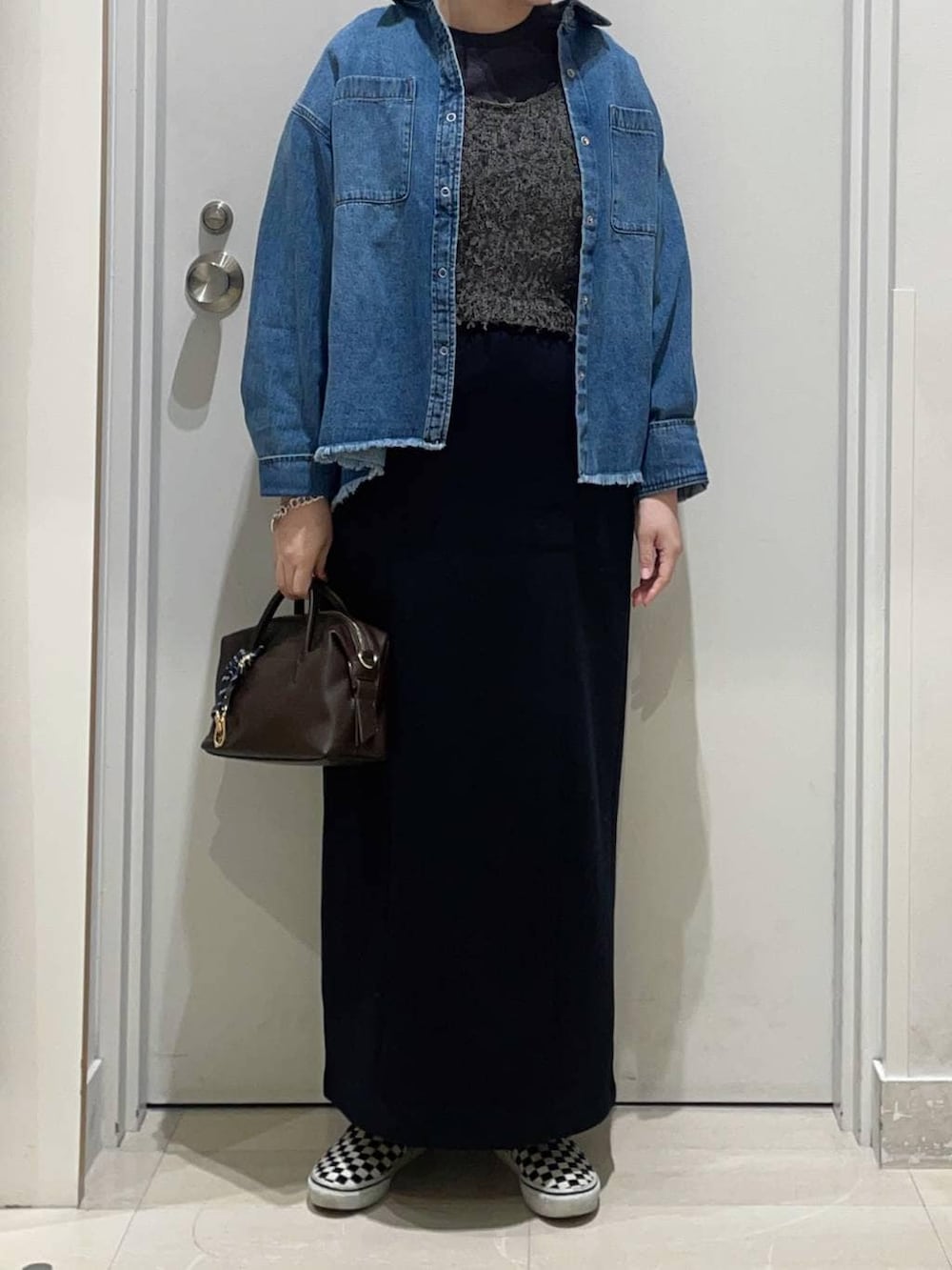 ブルー系のシャツ/ブラウス、ブラック系のスカート、グレー系のTシャツ/カットソーを着用したレディースの春コーディネートの2枚目の写真