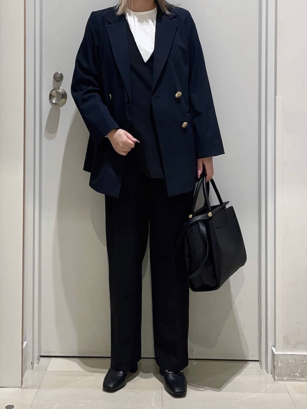ブラック系のローファー、ブラック系のトートバッグ、ブルー系のテーラードジャケットを着用したレディースの春コーディネートの2枚目の写真