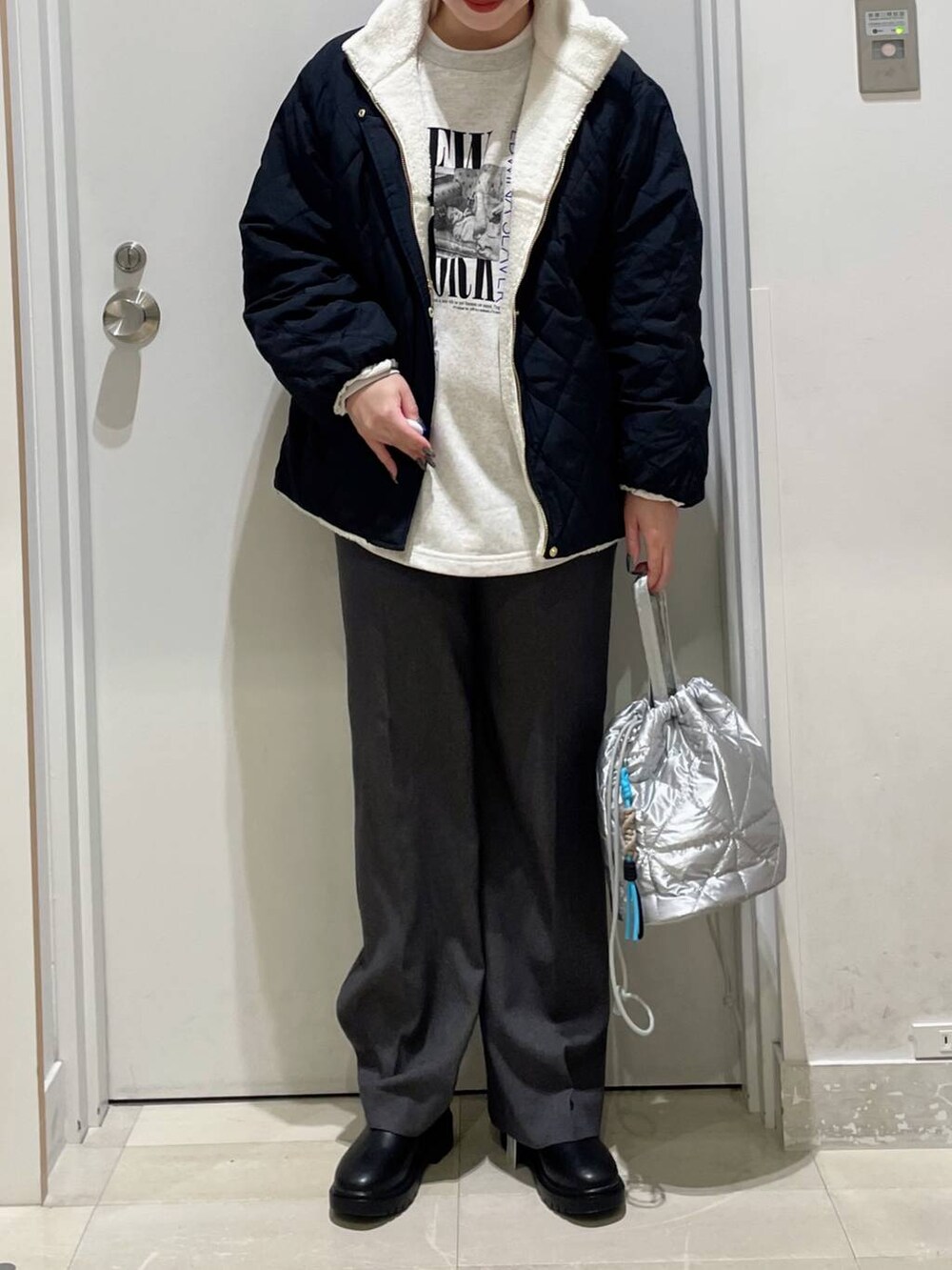 ホワイト系のブルゾン、シルバー系のハンドバッグ、グレー系のその他パンツを着用したレディースの秋コーディネートの2枚目の写真