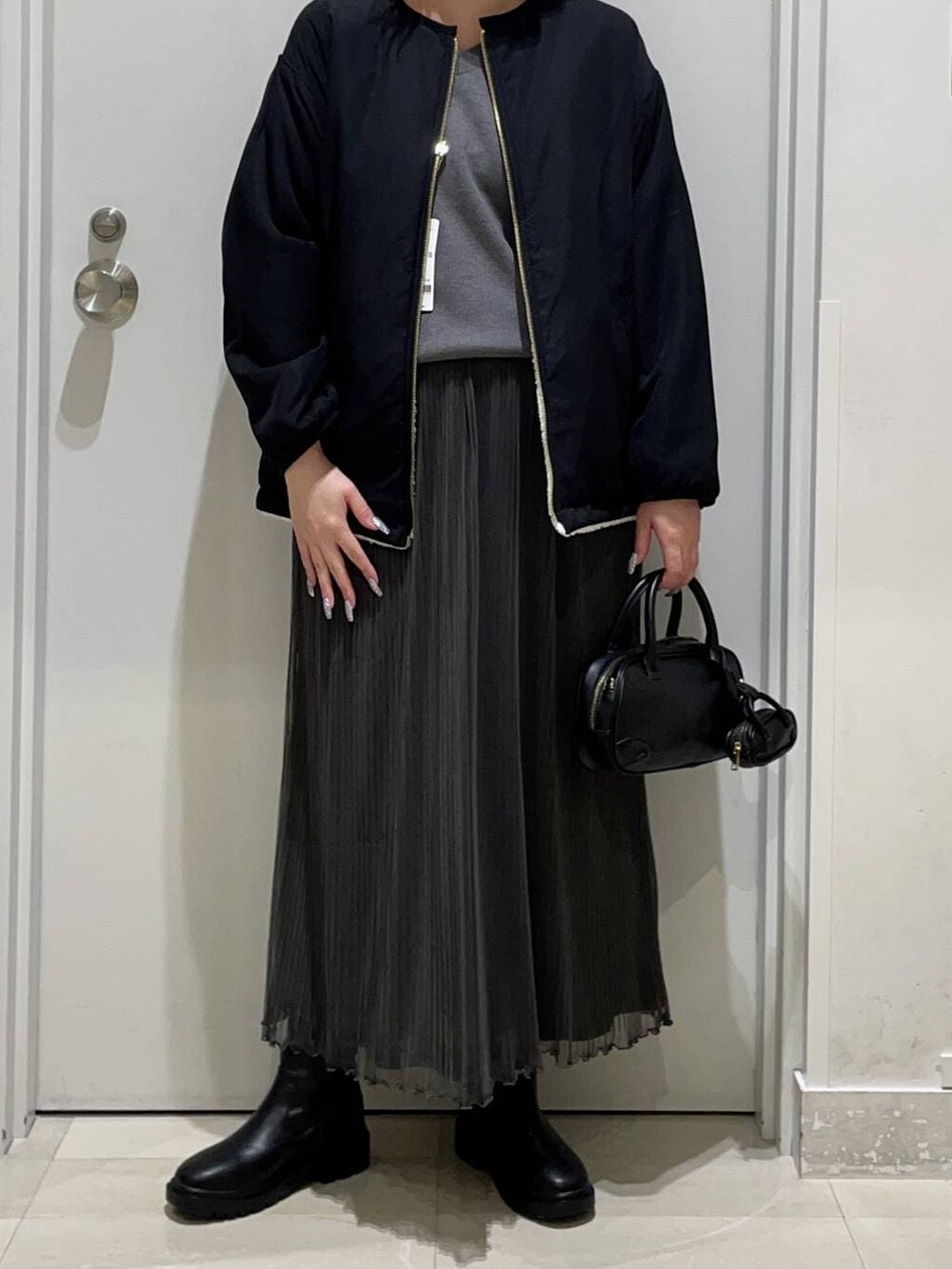 ホワイト系のブルゾン、グレー系のスウェット、ブラック系のブーツを着用したレディースの冬コーディネートの2枚目の写真