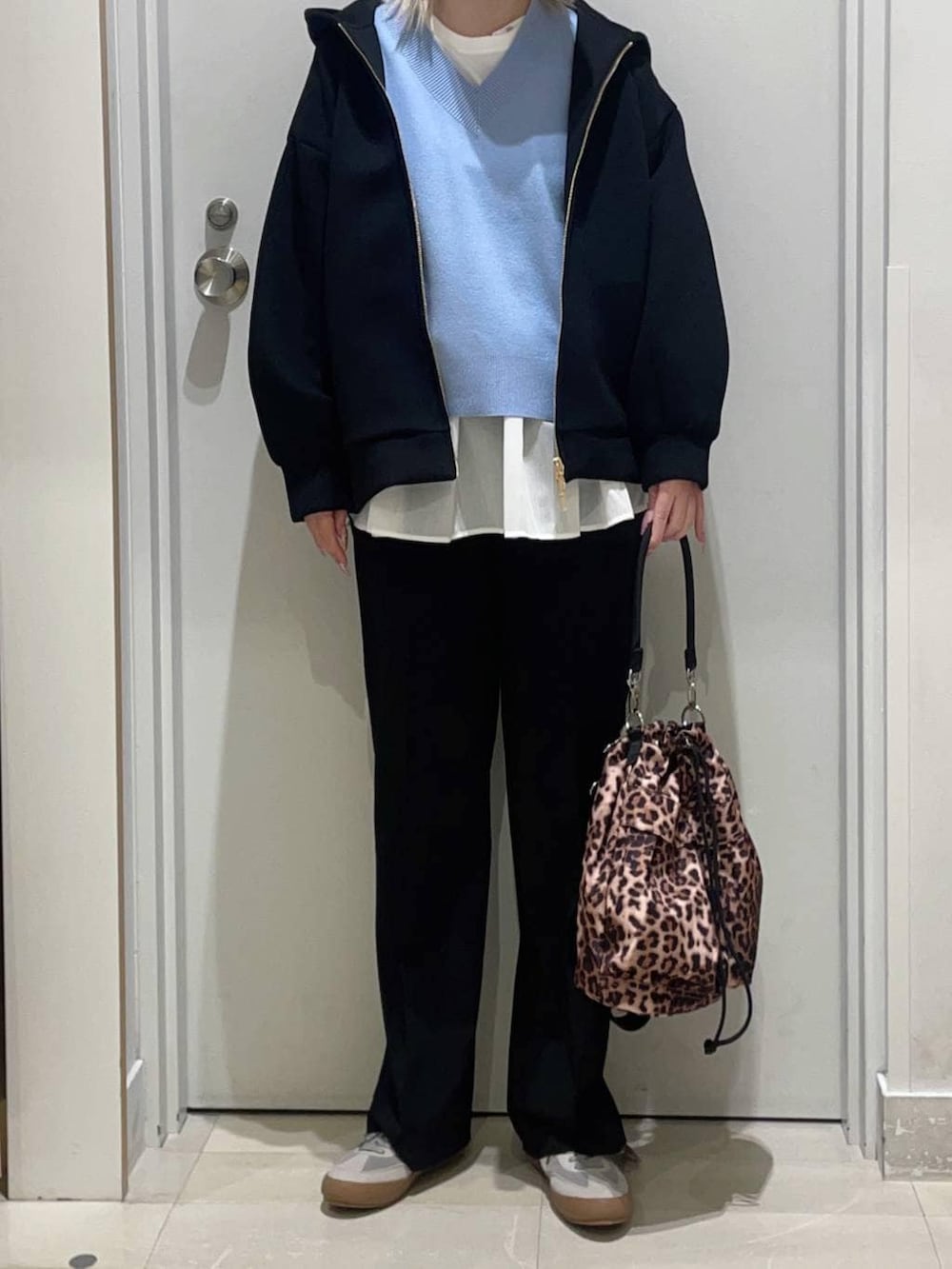 グレー系のスニーカー、ブルー系のニット/セーター、ホワイト系のTシャツ/カットソーを着用したレディースの冬コーディネートの2枚目の写真