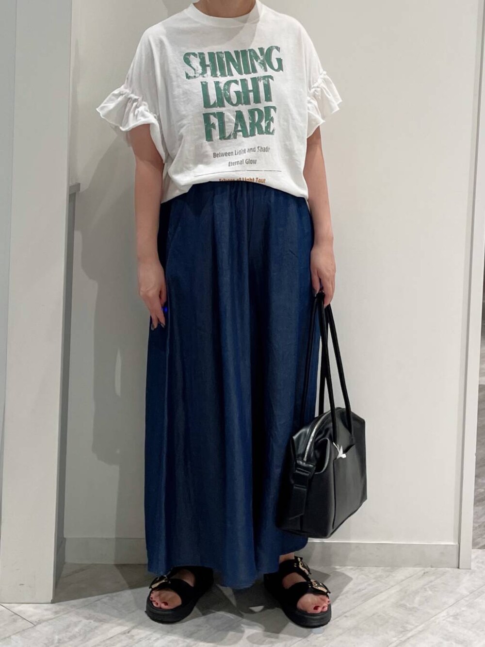 ブルー系のその他パンツ、ホワイト系のTシャツ/カットソー、ブラック系のサンダルを着用したレディースの夏コーディネートの2枚目の写真