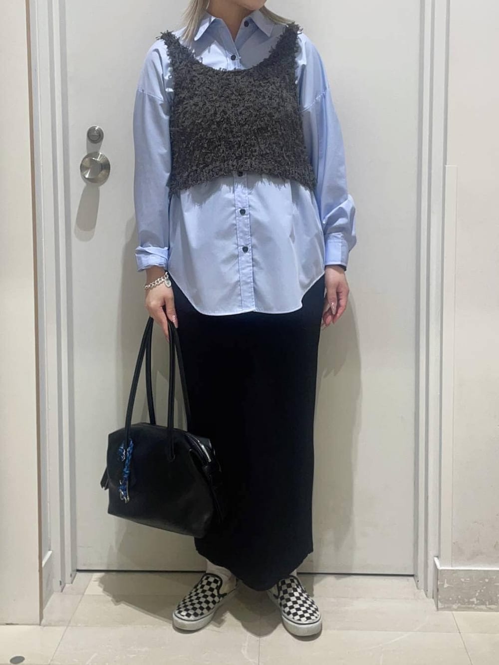 ブルー系のシャツ/ブラウス、ブラック系のスカート、ブラック系のボストンバッグを着用したレディースの春コーディネートの2枚目の写真