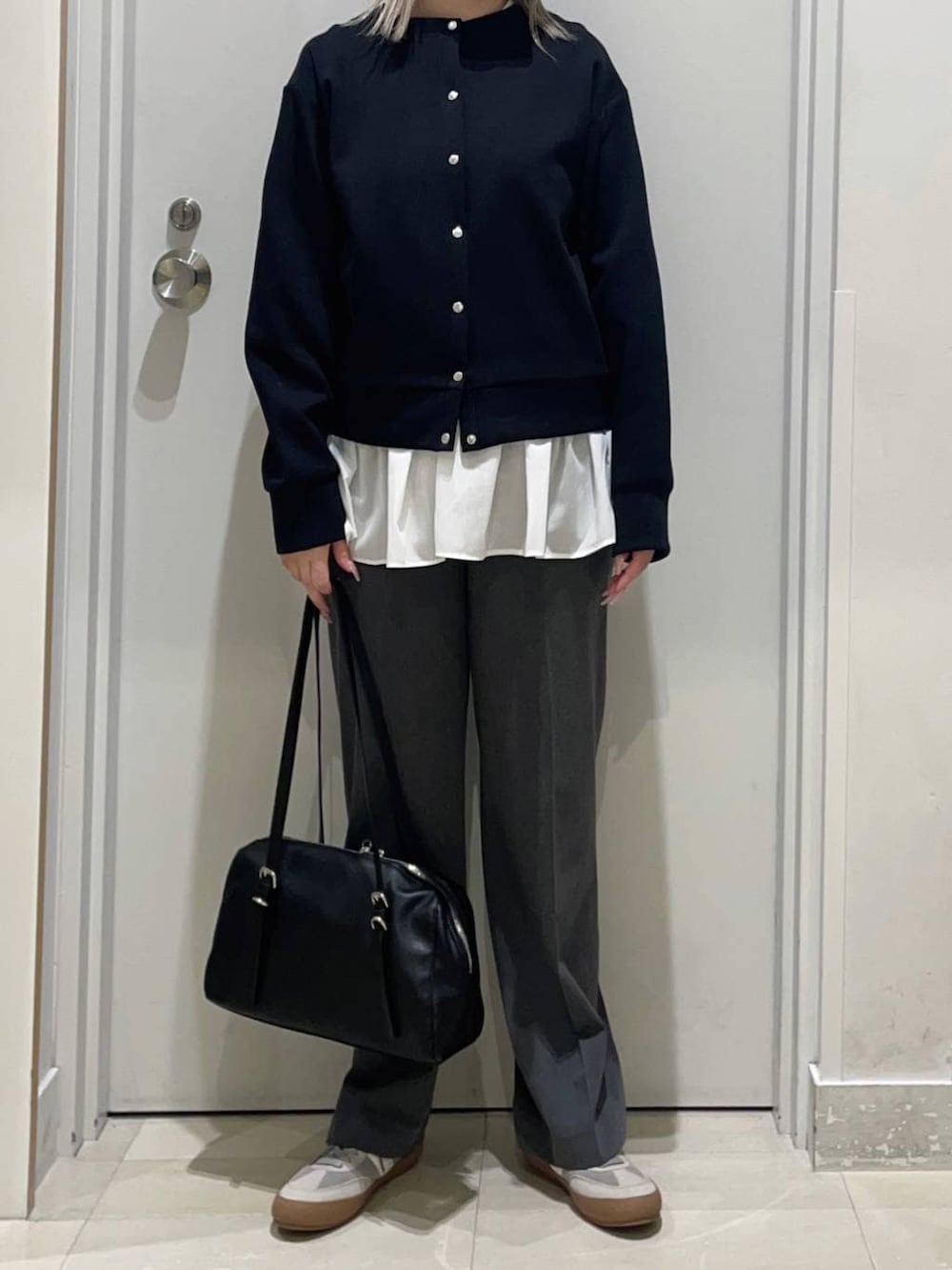 グレー系のスニーカー、ホワイト系のTシャツ/カットソー、グレー系のスラックスを着用したレディースの冬コーディネートの2枚目の写真