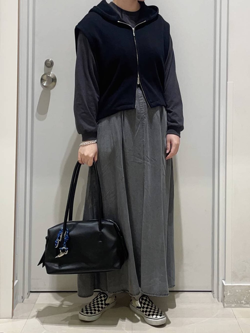 グレー系のTシャツ/カットソー、ブラック系のデニムスカート、ブラック系のボストンバッグを着用したレディースの春コーディネートの2枚目の写真