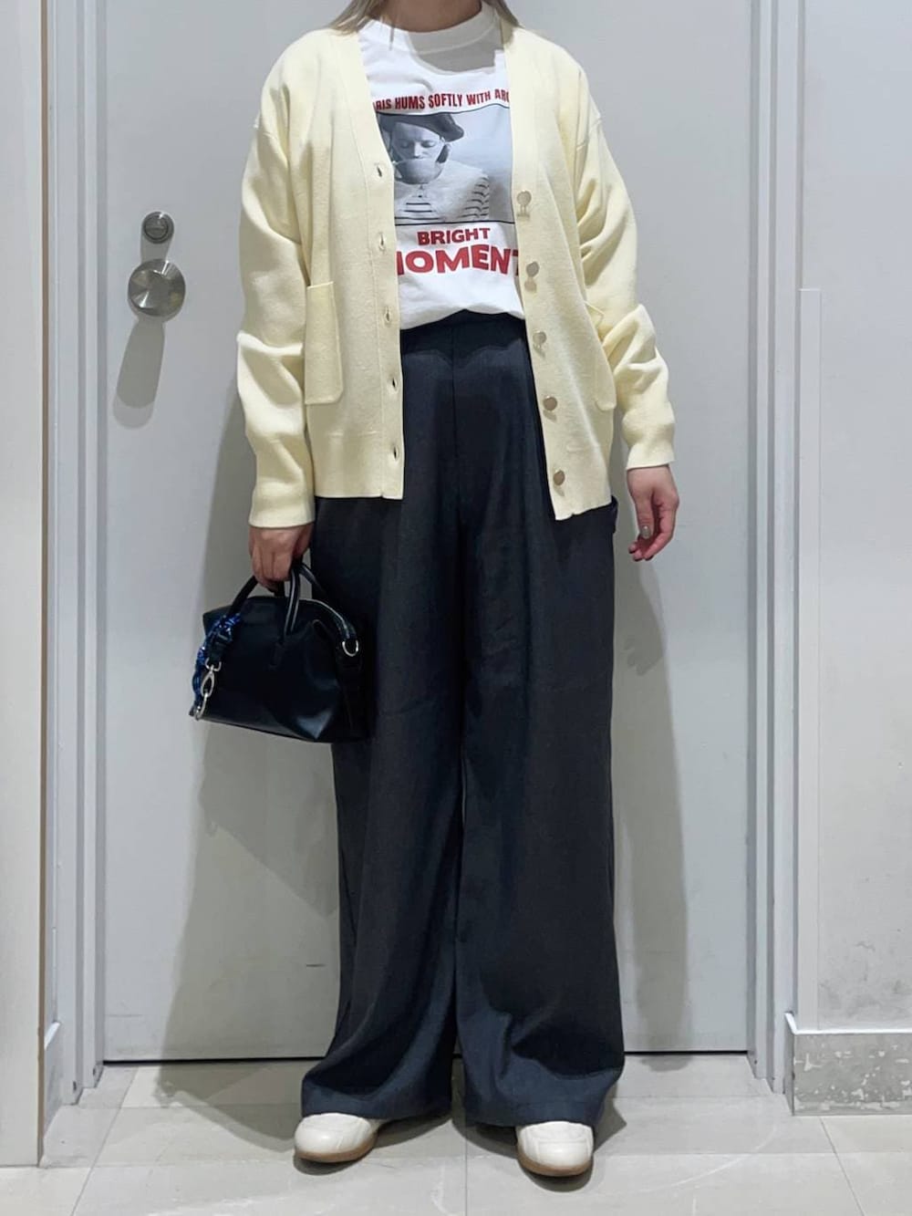 イエロー系のカーディガン/ボレロ、グレー系のその他パンツ、ホワイト系のTシャツ/カットソーを着用したレディースの春コーディネートの2枚目の写真