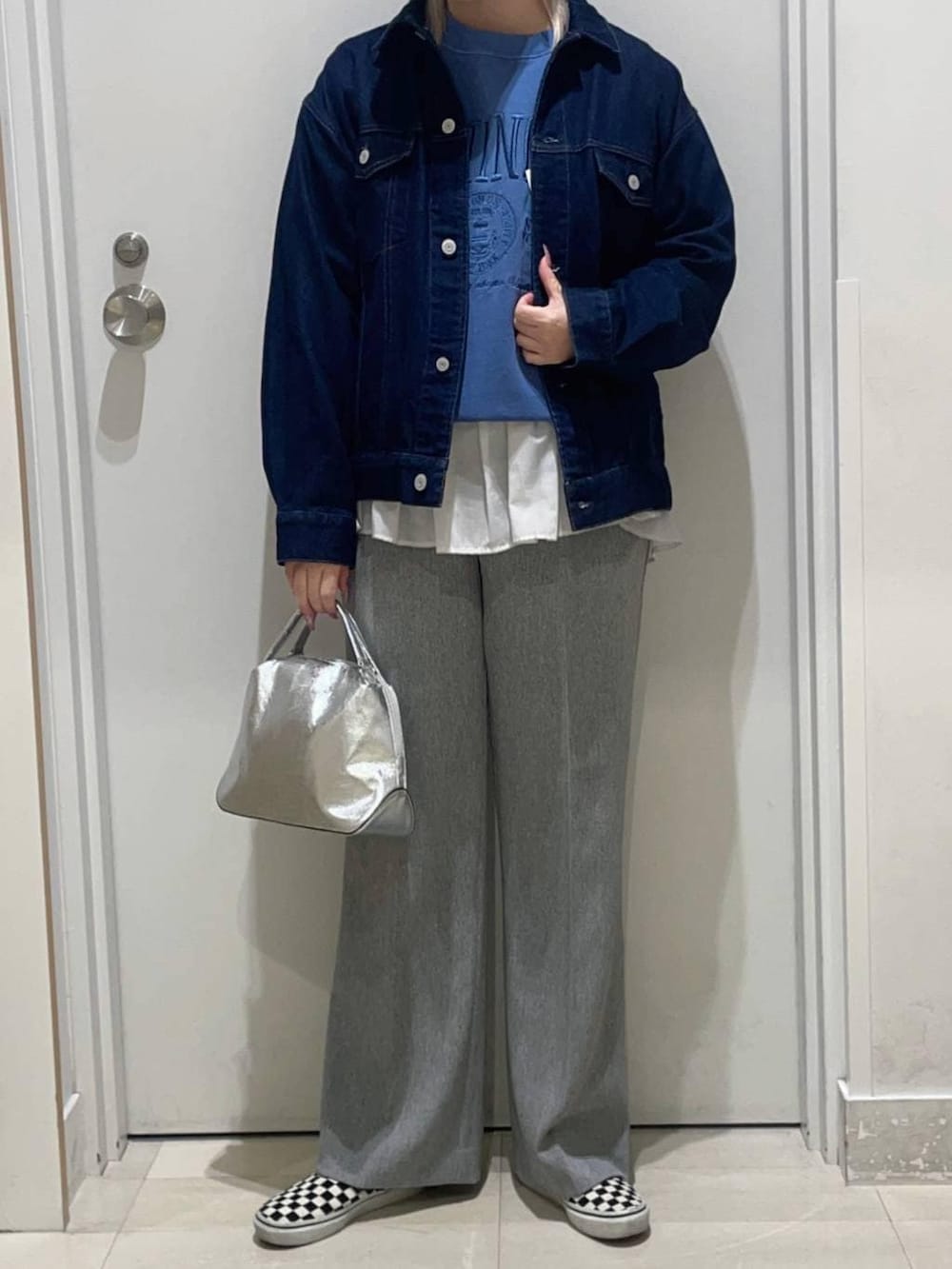 シルバー系のショルダーバッグ、ホワイト系のTシャツ/カットソー、ブルー系のデニムジャケットを着用したレディースの冬コーディネートの2枚目の写真