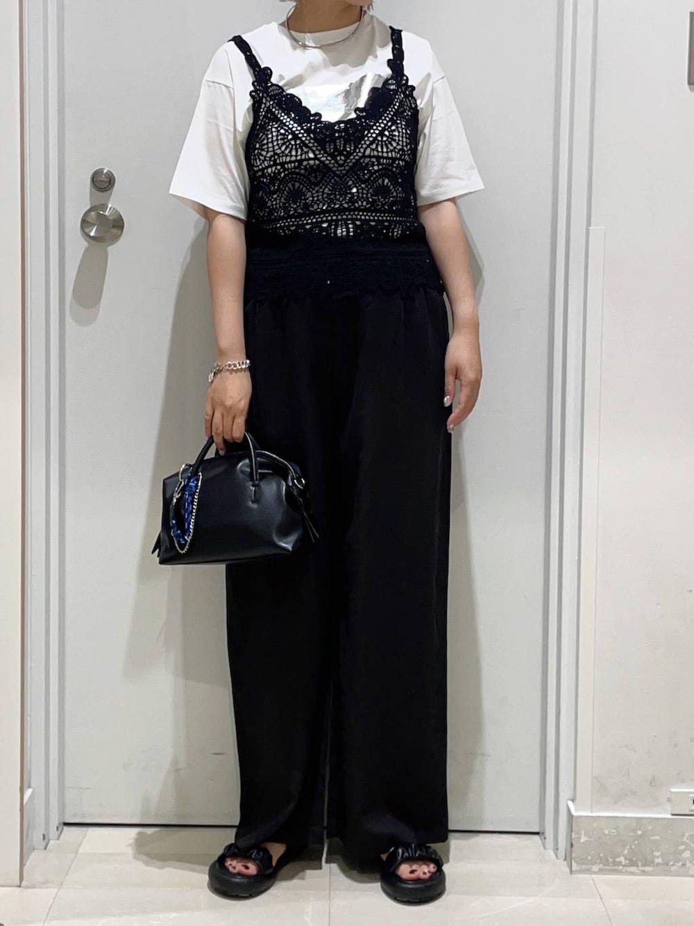 ブラック系のその他パンツ、ホワイト系のTシャツ/カットソー、ブラック系のボストンバッグを着用したレディースの夏コーディネートの2枚目の写真