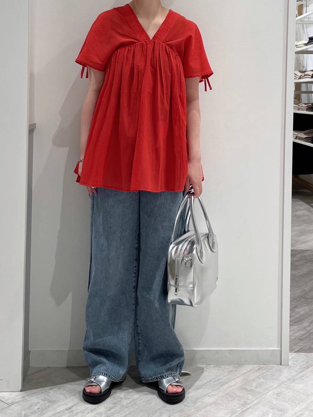 ブルー系のデニムパンツ、グレー系のボストンバッグ、ホワイト系のタンクトップを着用したレディースの春コーディネートの2枚目の写真