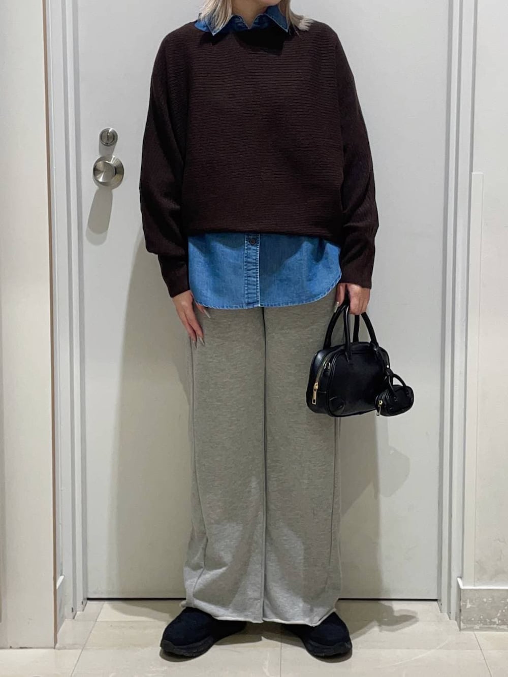 ブルー系のシャツ/ブラウス、ブラック系のハンドバッグ、ブラック系のその他シューズを着用したレディースの冬コーディネートの2枚目の写真