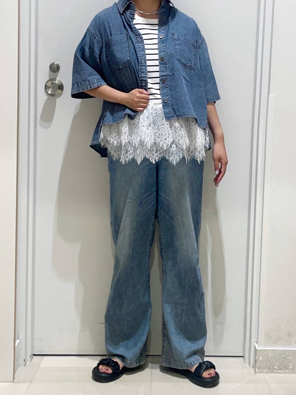 ブルー系のデニムパンツ、ブルー系のシャツ/ブラウス、ブラック系のサンダルを着用したレディースの夏コーディネートの2枚目の写真