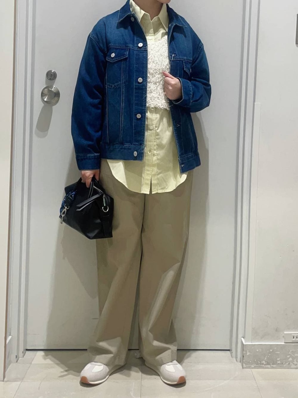 イエロー系のシャツ/ブラウス、ベージュ系のスニーカー、ブルー系のデニムジャケットを着用したレディースの春コーディネートの2枚目の写真