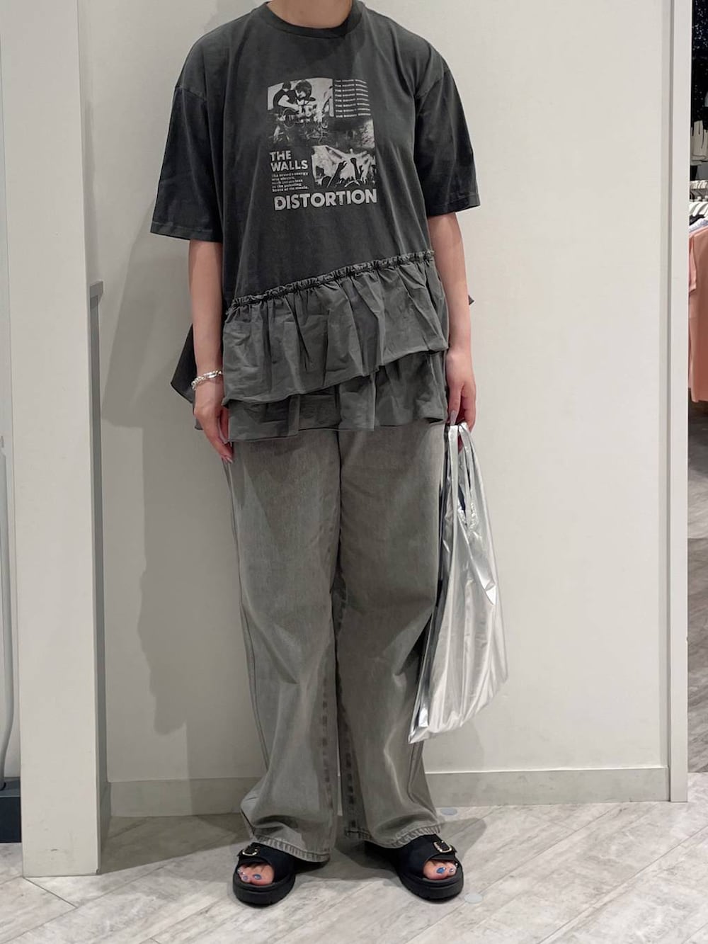 グレー系のデニムパンツ、グレー系のエコバッグ/サブバッグ、グレー系のTシャツ/カットソーを着用したレディースの夏コーディネートの2枚目の写真