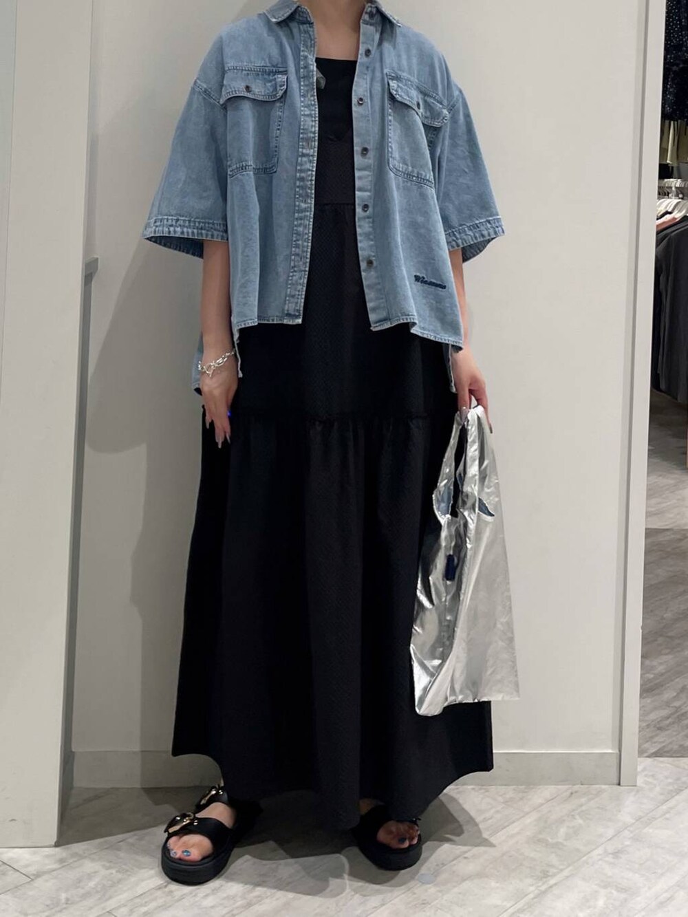 グレー系のエコバッグ/サブバッグ、ブラック系のタンクトップ、ブルー系のシャツ/ブラウスを着用したレディースの夏コーディネートの2枚目の写真