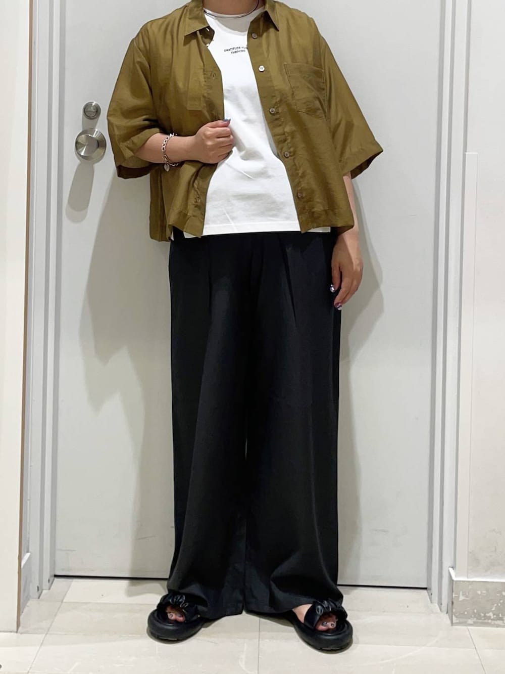 ブラック系のその他パンツ、グリーン系のシャツ/ブラウス、ホワイト系のTシャツ/カットソーを着用したレディースの夏コーディネートの2枚目の写真