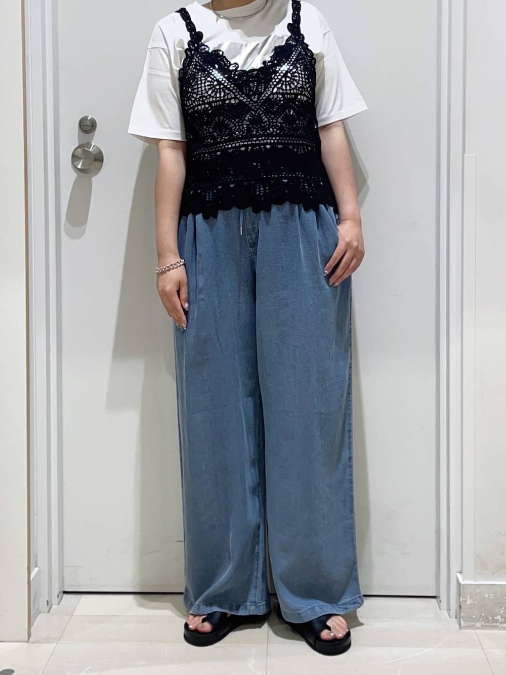 ホワイト系のTシャツ/カットソー、ブルー系のデニムパンツ、ブラック系のサンダルを着用したレディースの夏コーディネートの2枚目の写真