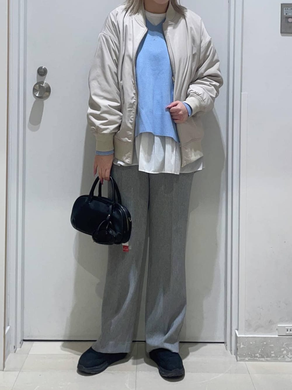 ベージュ系のブルゾン、ブルー系のニット/セーター、グレー系のその他パンツを着用したレディースの冬コーディネートの2枚目の写真