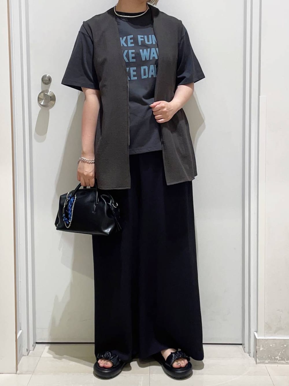 グレー系のベスト、ブラック系のその他パンツ、グレー系のTシャツ/カットソーを着用したレディースの春コーディネートの2枚目の写真