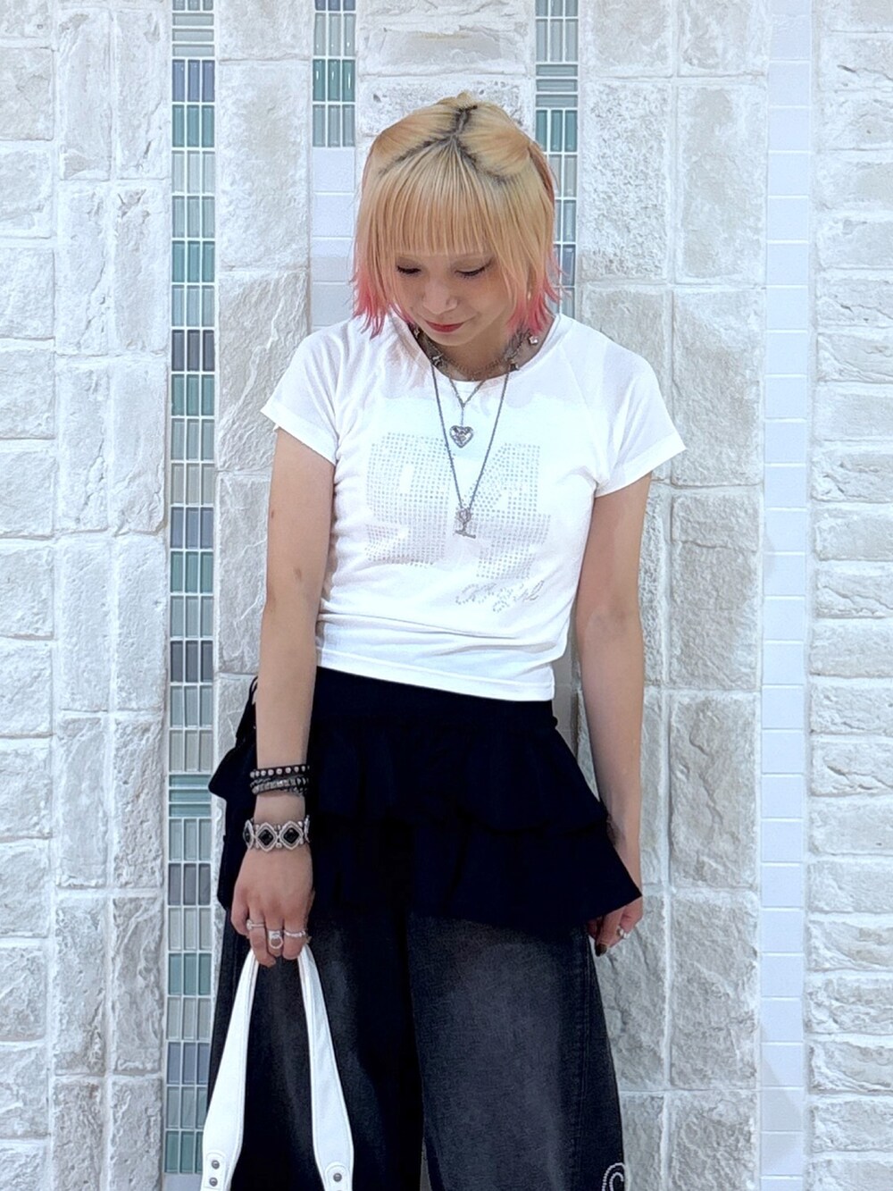 ホワイト系のTシャツ/カットソー、ブラック系のスカート、ブラック系のデニムパンツを着用したレディースの夏コーディネートの5枚目の写真