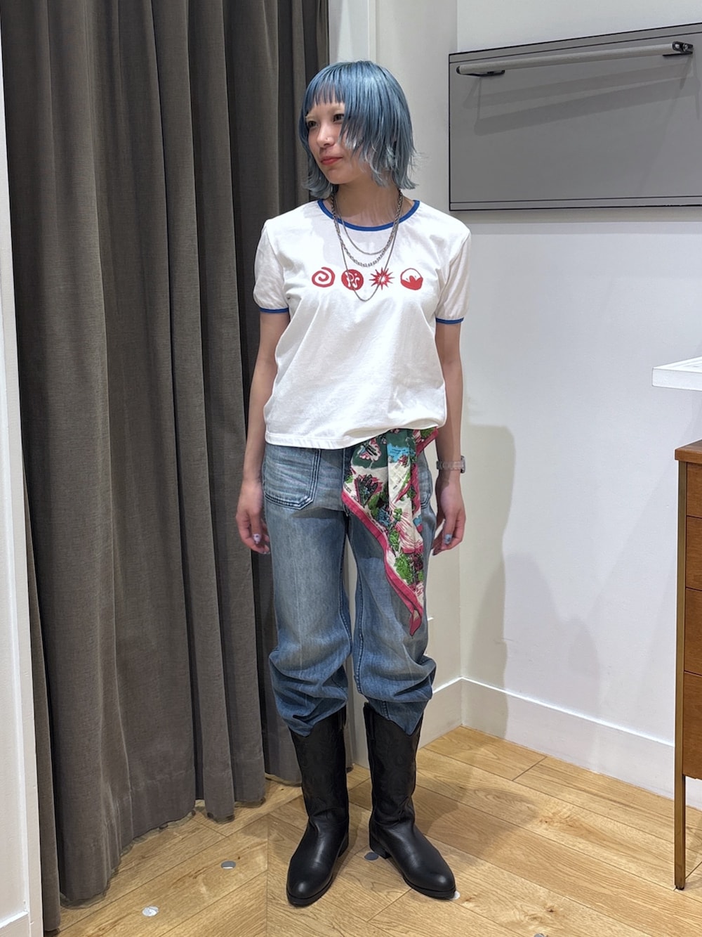 ブルー系のデニムジャケット、ブラック系のブーツ、ブルー系のデニムパンツを着用したレディースの春コーディネートの7枚目の写真
