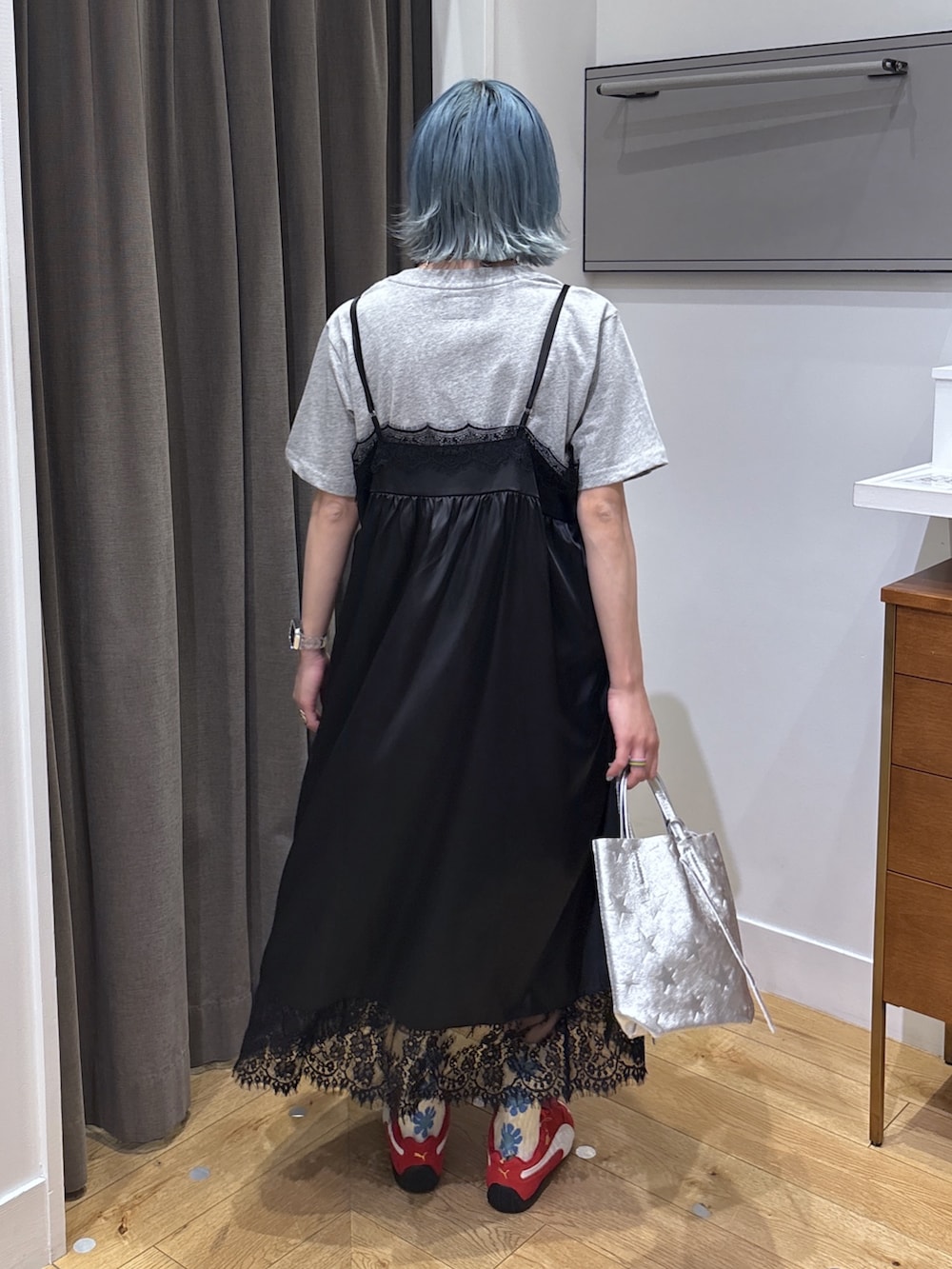 シルバー系のショルダーバッグ、ブラック系のワンピース、レッド系のスニーカーを着用したレディースの春コーディネートの4枚目の写真