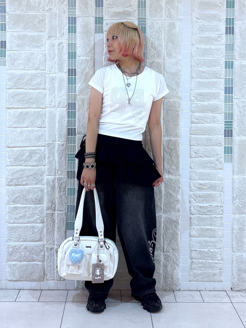 ホワイト系のTシャツ/カットソー、ブラック系のスカート、ブラック系のデニムパンツを着用したレディースの夏コーディネートの2枚目の写真