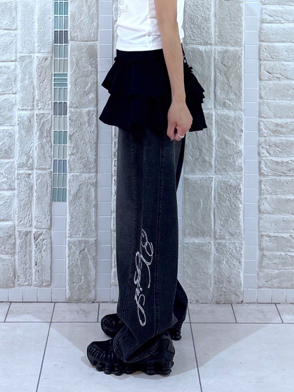 ホワイト系のTシャツ/カットソー、ブラック系のスカート、ブラック系のデニムパンツを着用したレディースの夏コーディネートの6枚目の写真