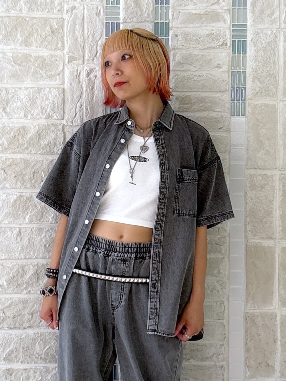 ブラック系のデニムパンツ、グレー系のショルダーバッグ、ブラック系のシャツ/ブラウスを着用したレディースの夏コーディネートの7枚目の写真