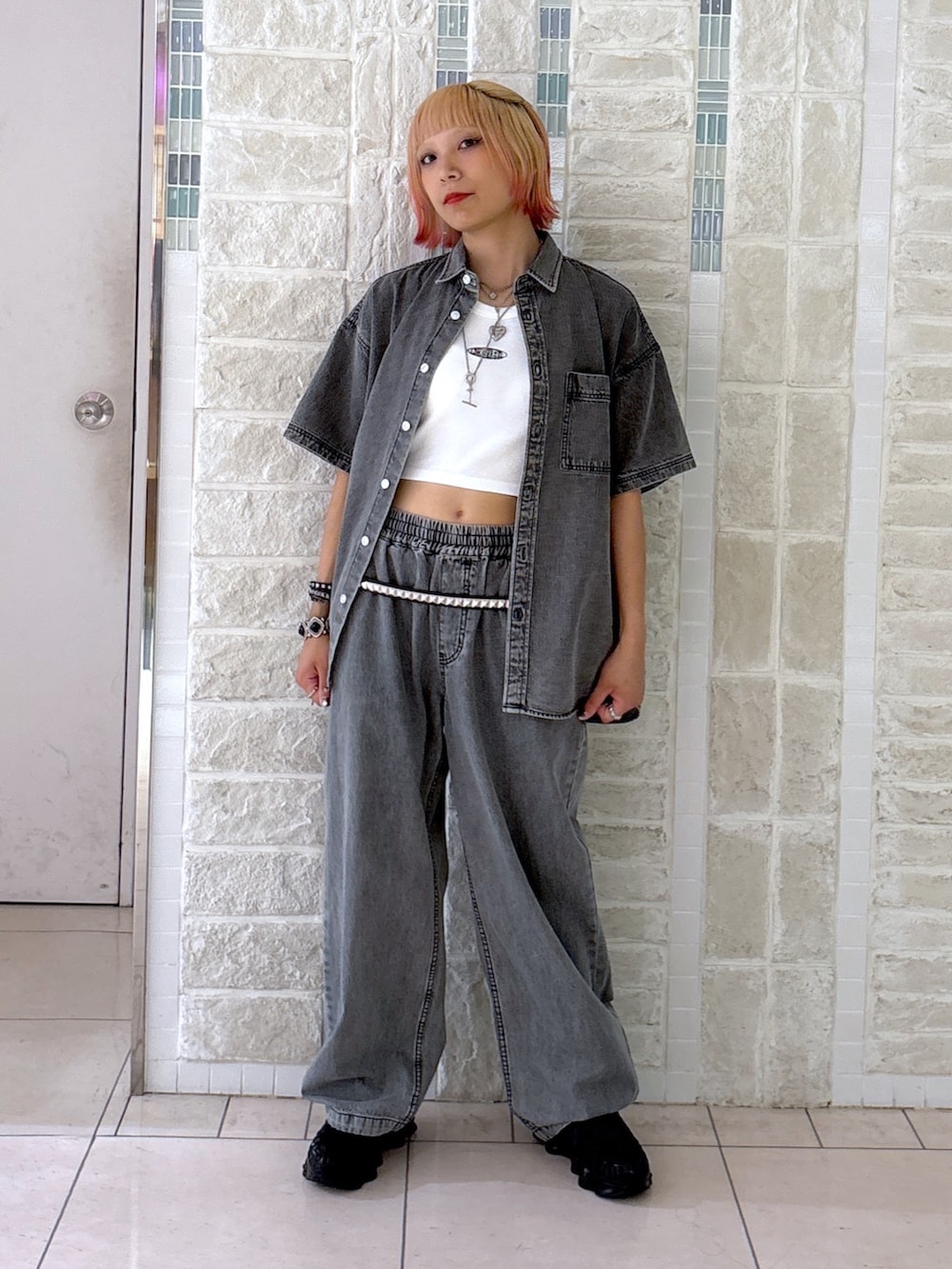 ブラック系のデニムパンツ、グレー系のショルダーバッグ、ブラック系のシャツ/ブラウスを着用したレディースの夏コーディネートの6枚目の写真