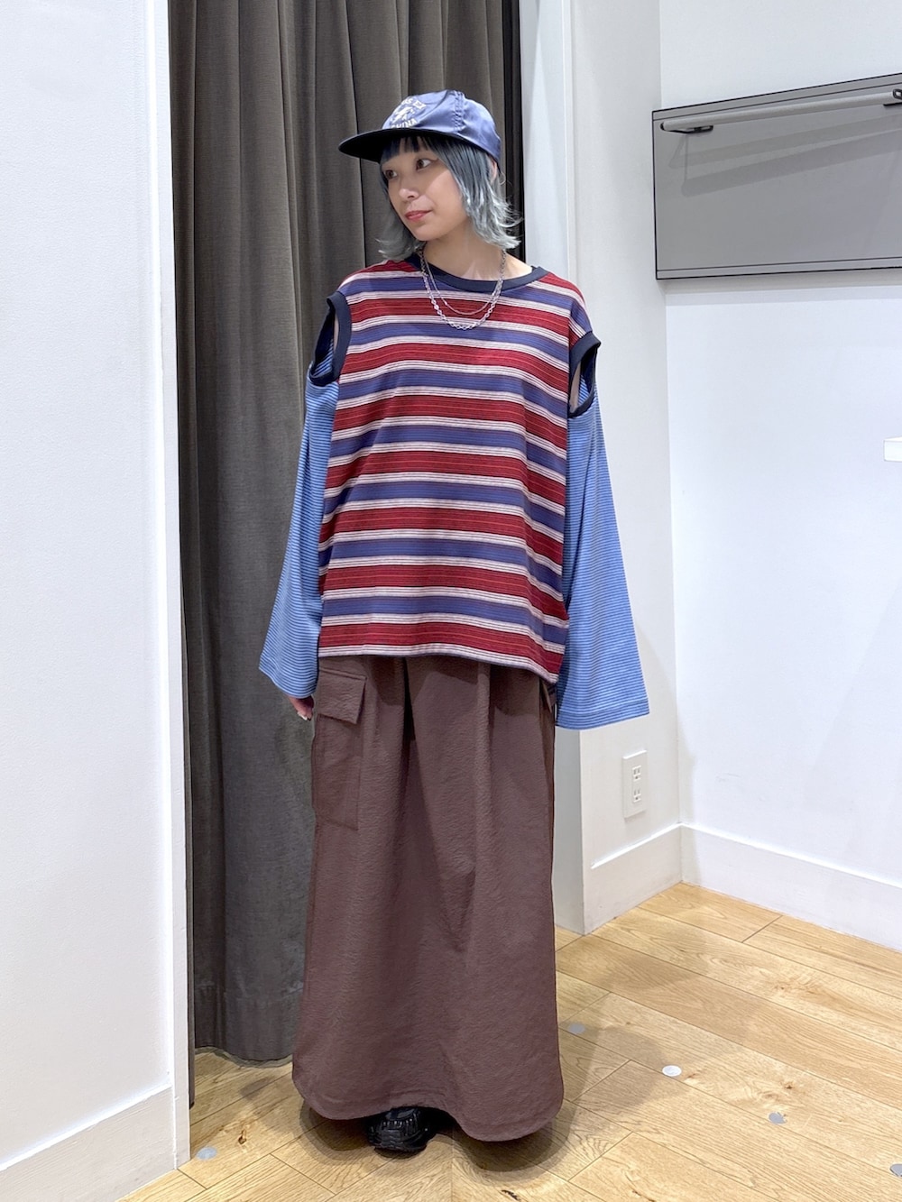 ブラック系のショルダーバッグ、ブルー系のTシャツ/カットソー、ブラウン系のスカートを着用したレディースの夏コーディネートの5枚目の写真
