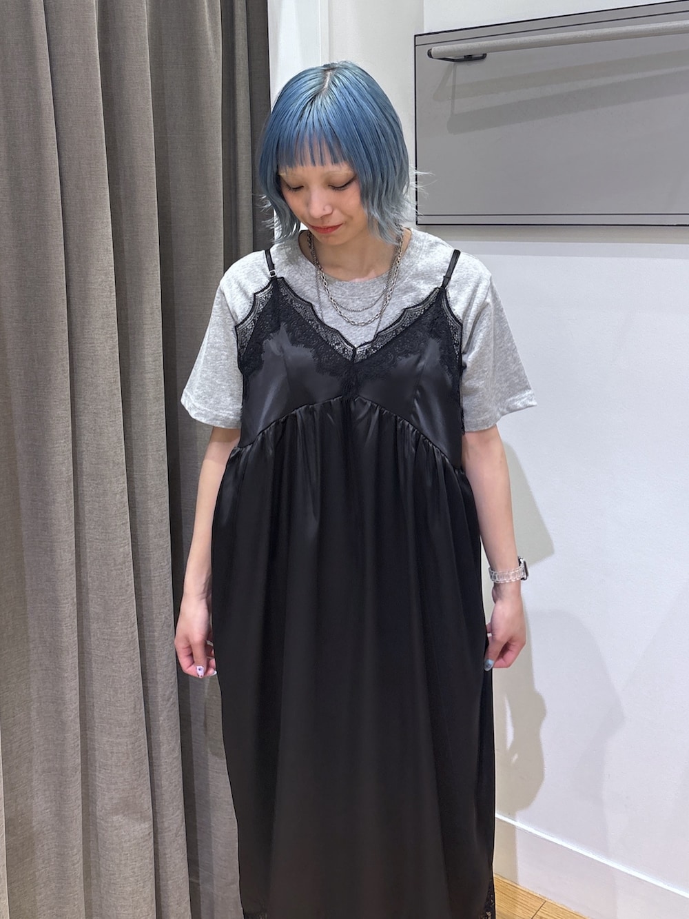 シルバー系のショルダーバッグ、ブラック系のワンピース、レッド系のスニーカーを着用したレディースの春コーディネートの5枚目の写真