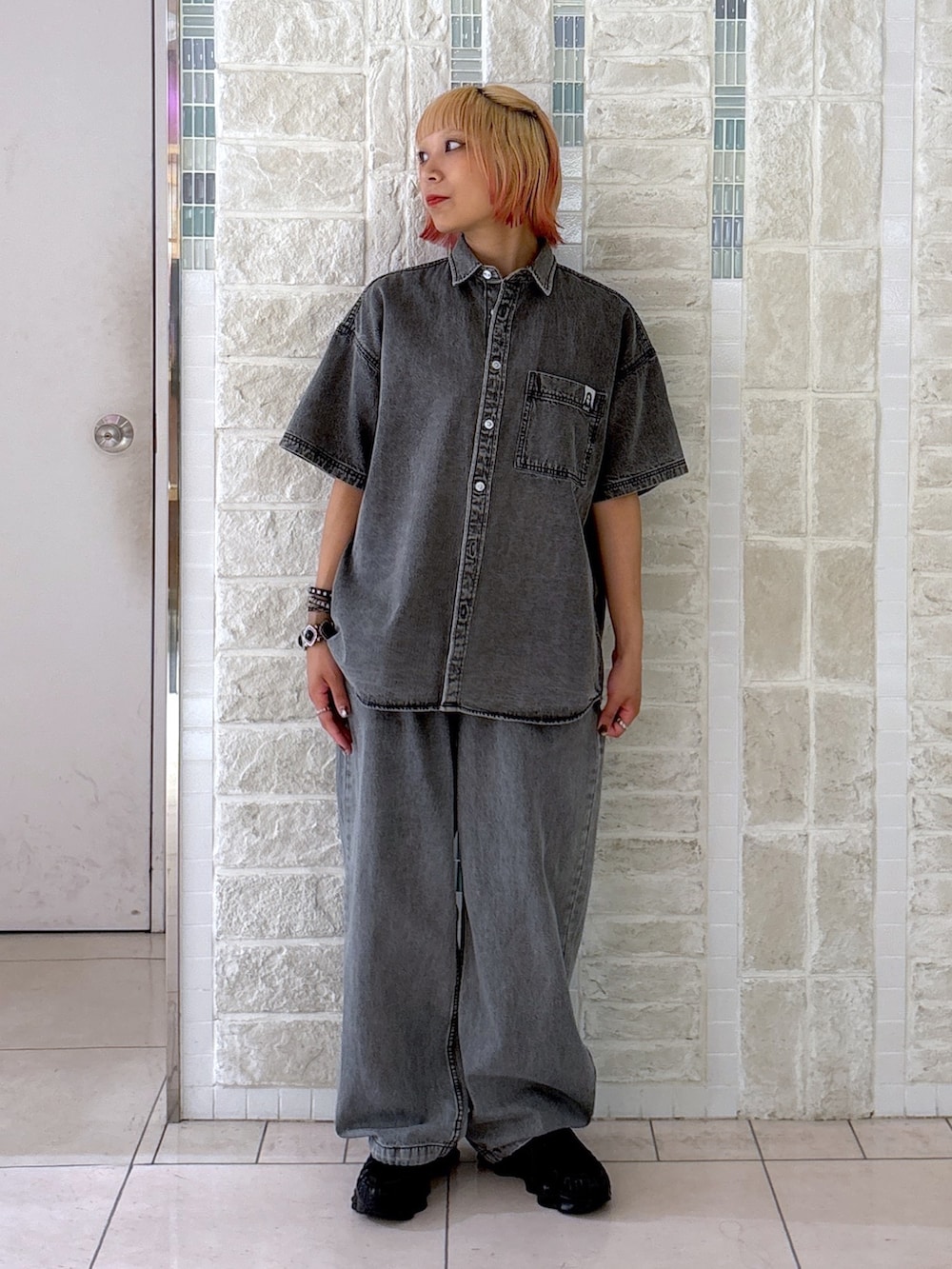 ブラック系のデニムパンツ、グレー系のショルダーバッグ、ブラック系のシャツ/ブラウスを着用したレディースの夏コーディネートの3枚目の写真