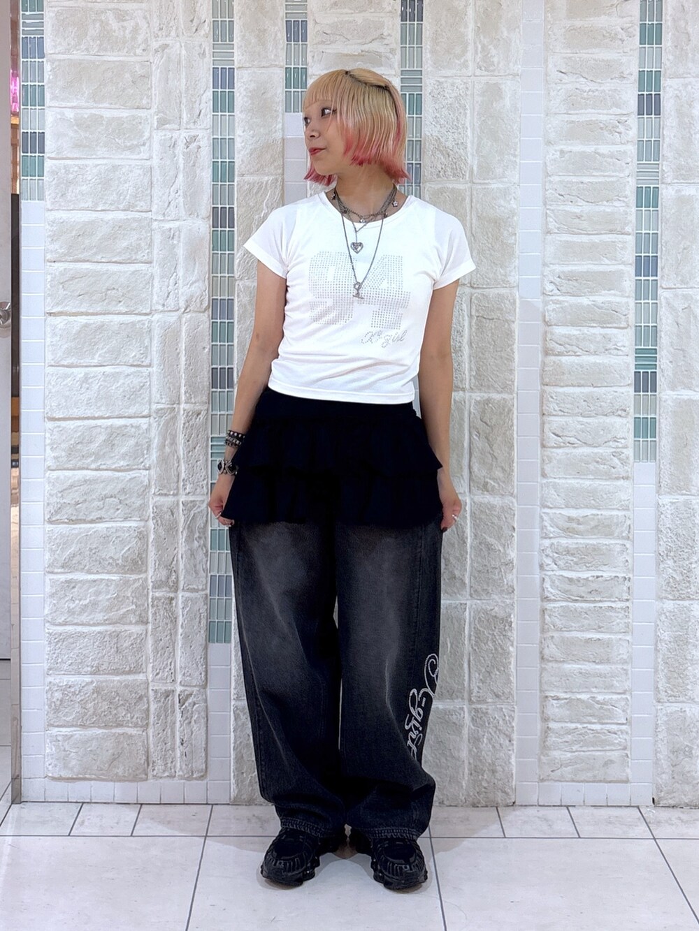 ホワイト系のTシャツ/カットソー、ブラック系のスカート、ブラック系のデニムパンツを着用したレディースの夏コーディネートの4枚目の写真