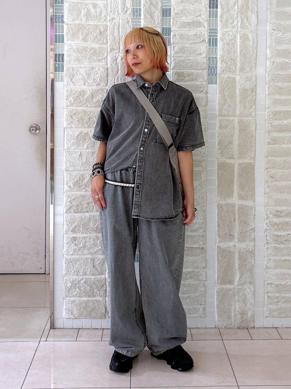 ブラック系のデニムパンツ、グレー系のショルダーバッグ、ブラック系のシャツ/ブラウスを着用したレディースの夏コーディネートの2枚目の写真