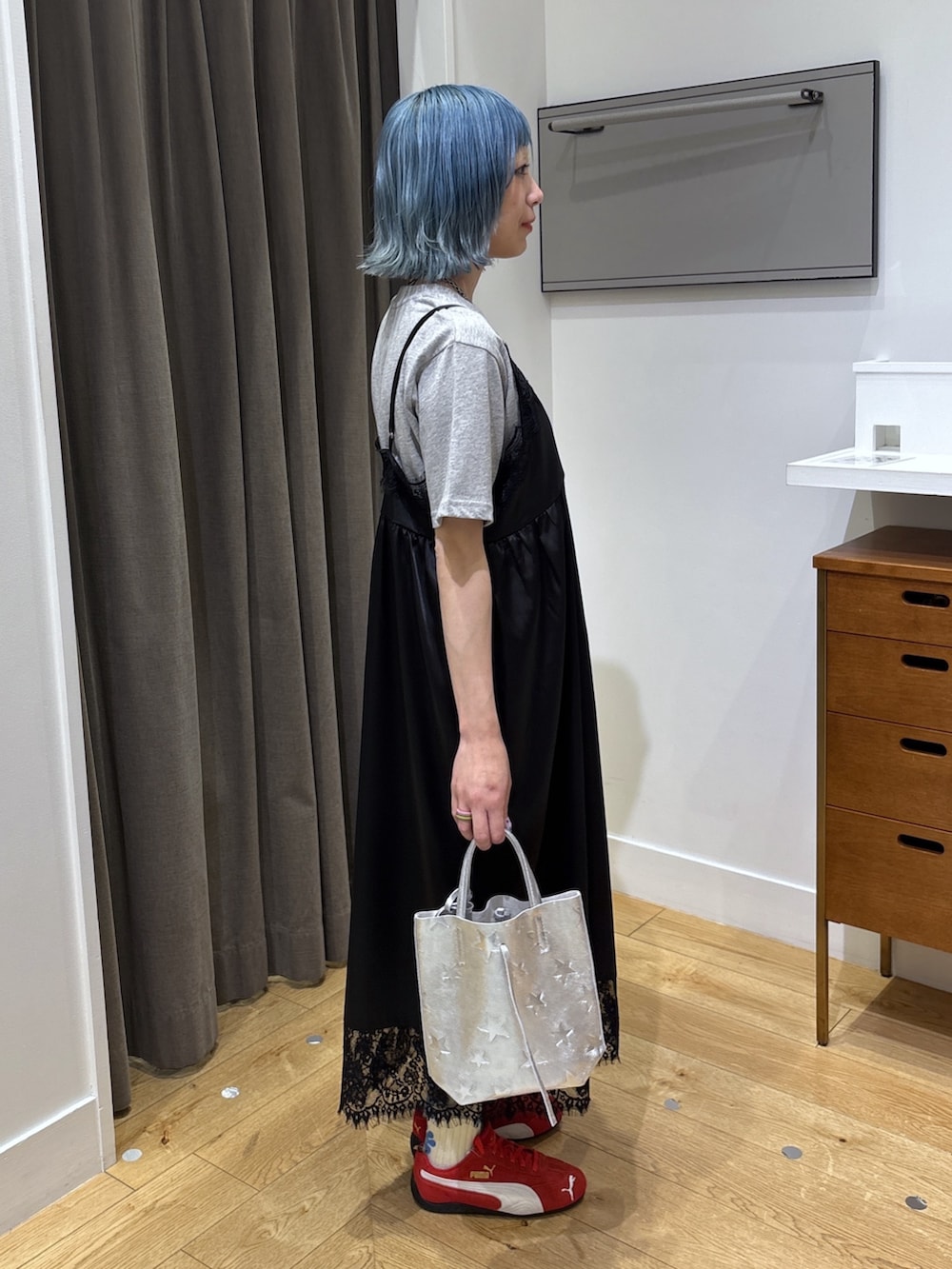 シルバー系のショルダーバッグ、ブラック系のワンピース、レッド系のスニーカーを着用したレディースの春コーディネートの8枚目の写真