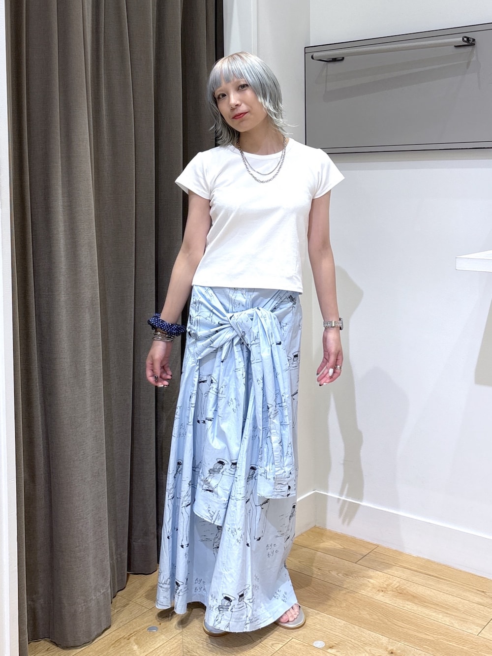 ベージュ系のトートバッグ、ブルー系のスカート、ホワイト系のTシャツ/カットソーを着用したレディースの夏コーディネートの7枚目の写真