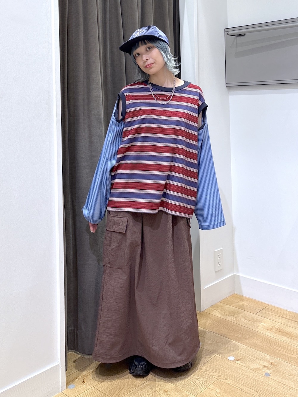 ブラック系のショルダーバッグ、ブルー系のTシャツ/カットソー、ブラウン系のスカートを着用したレディースの夏コーディネートの4枚目の写真