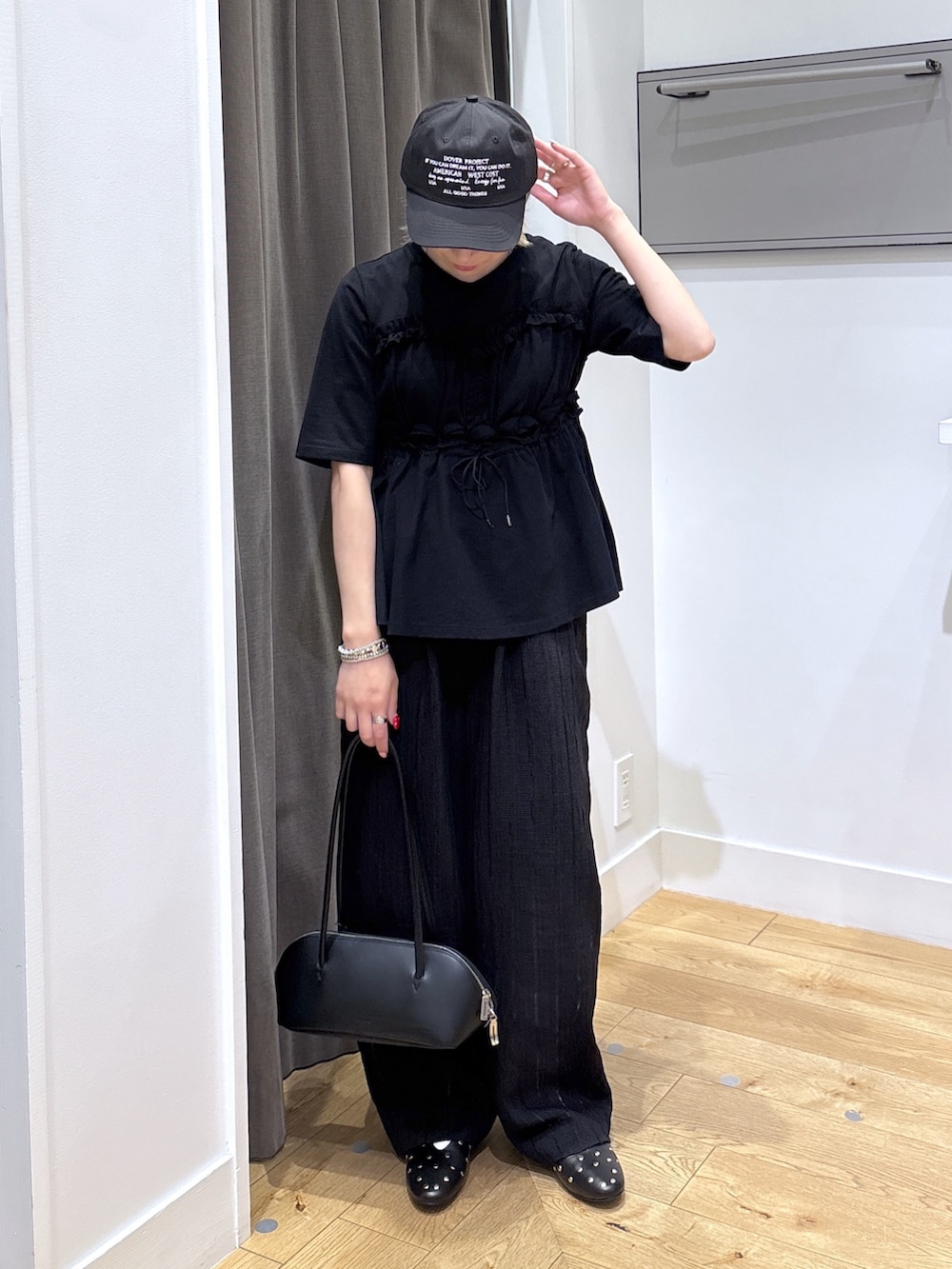 ブラック系のその他パンツ、ブラック系のTシャツ/カットソー、ブラック系のボストンバッグを着用したレディースの春コーディネートの2枚目の写真