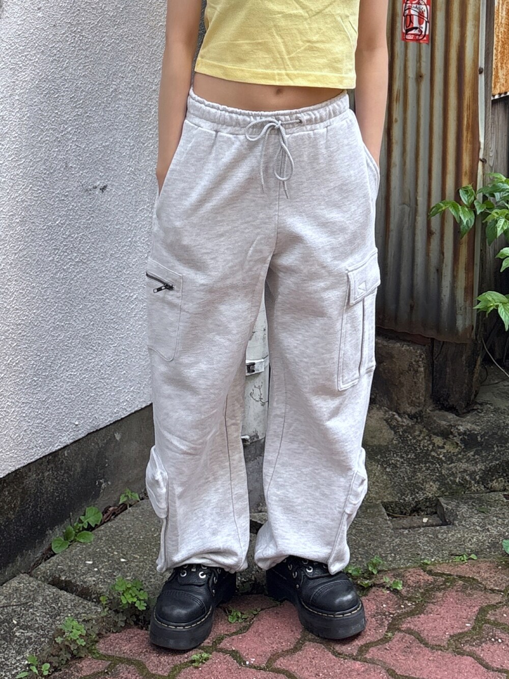 イエロー系のTシャツ/カットソー、グレー系のスウェットパンツ、その他のハンドバッグを着用したレディースの夏コーディネートの5枚目の写真