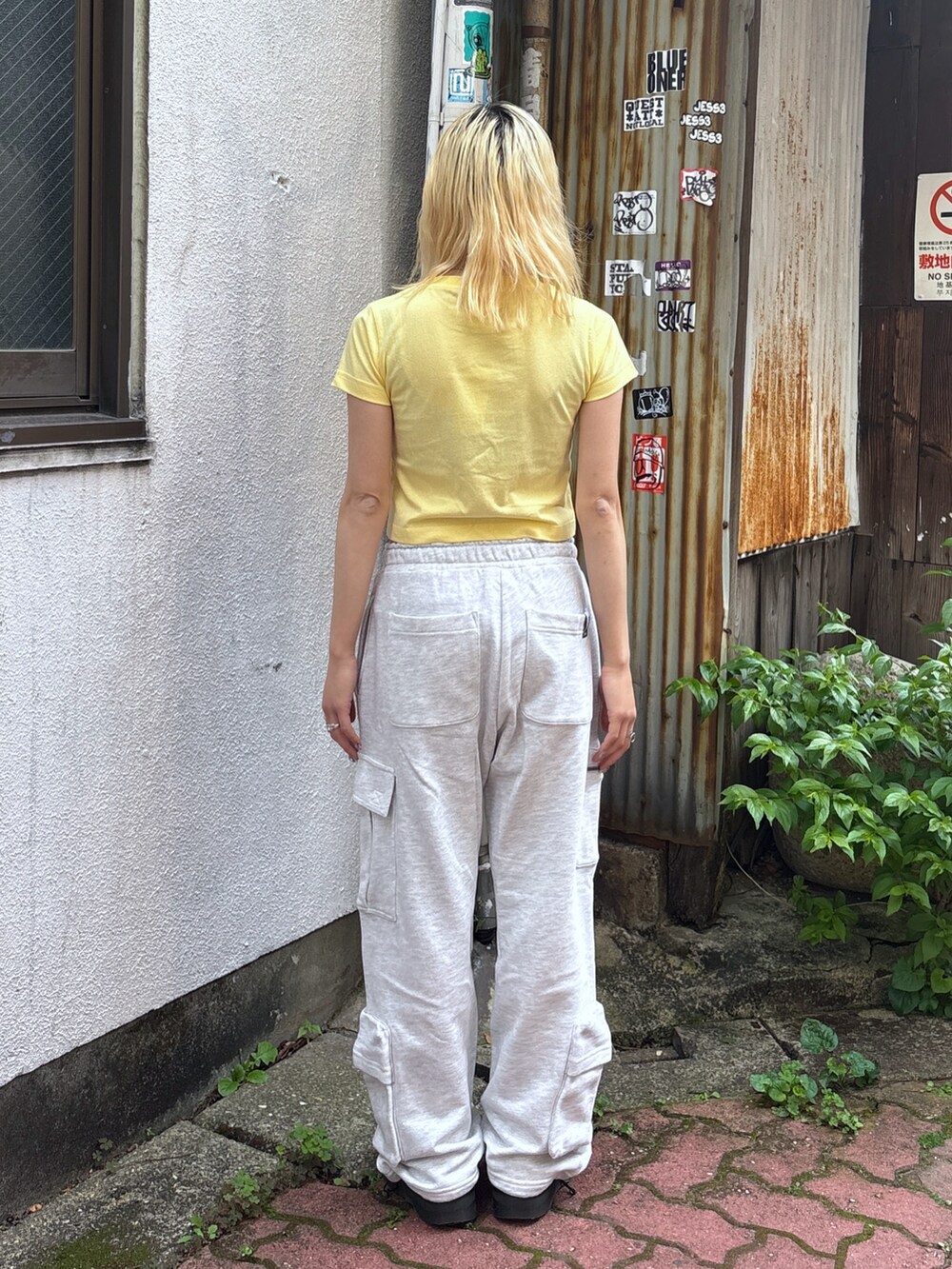 イエロー系のTシャツ/カットソー、グレー系のスウェットパンツ、その他のハンドバッグを着用したレディースの夏コーディネートの4枚目の写真