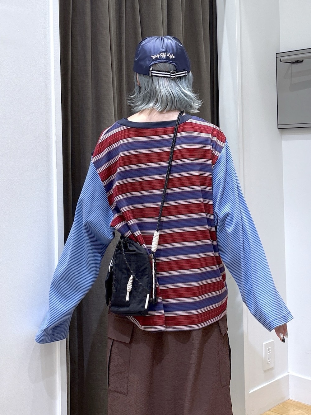 ブラック系のショルダーバッグ、ブルー系のTシャツ/カットソー、ブラウン系のスカートを着用したレディースの夏コーディネートの7枚目の写真