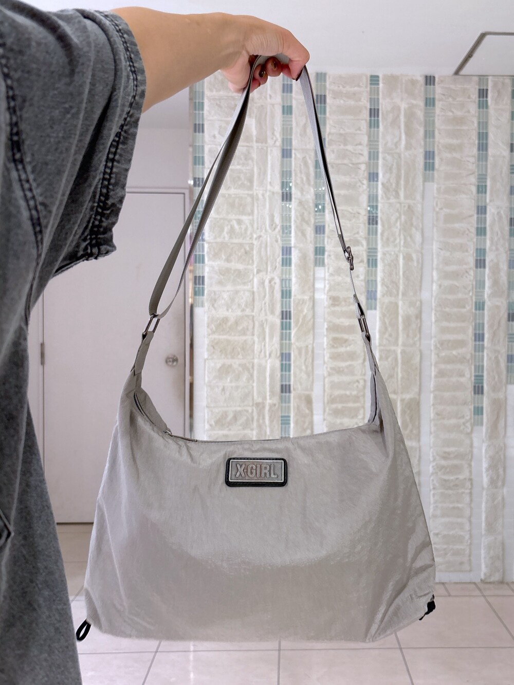 ブラック系のデニムパンツ、グレー系のショルダーバッグ、ブラック系のシャツ/ブラウスを着用したレディースの夏コーディネートの8枚目の写真