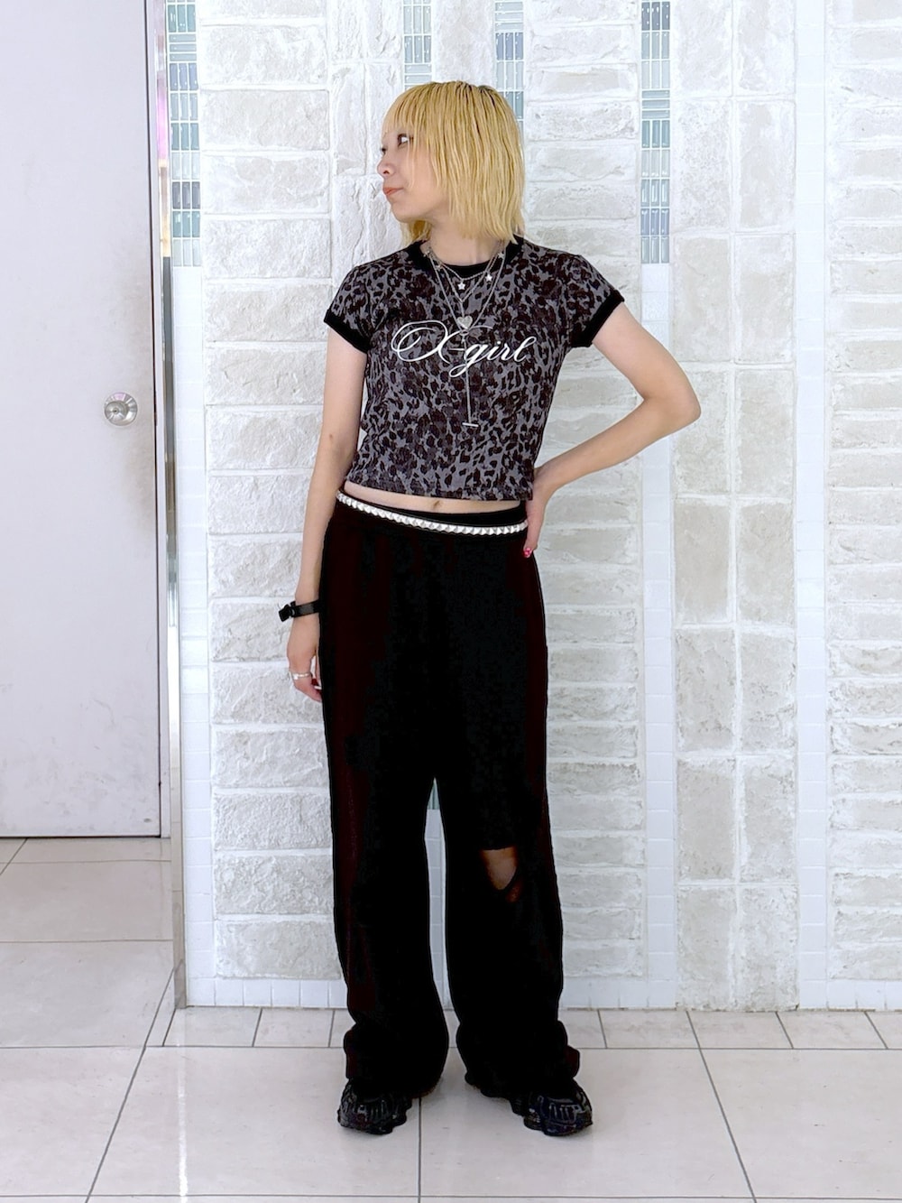 ブラック系のスウェットパンツ、グレー系のTシャツ/カットソー、ホワイト系のハンドバッグを着用したレディースの夏コーディネートの3枚目の写真