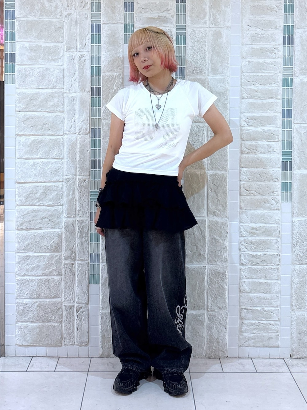 ホワイト系のTシャツ/カットソー、ブラック系のスカート、ブラック系のデニムパンツを着用したレディースの夏コーディネートの3枚目の写真